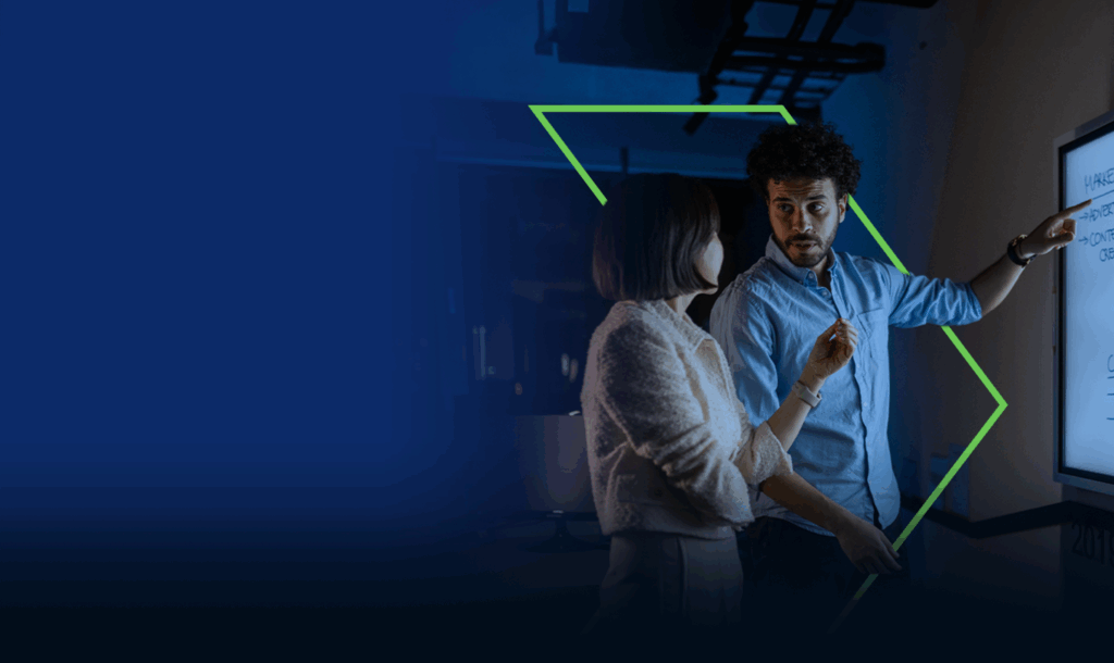 Two colleagues working together, standing at a illuminating screen.