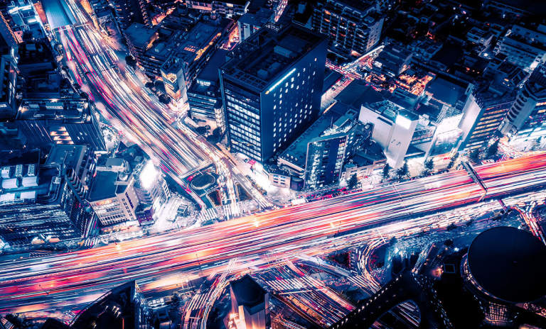 An aerial view of a busy city with busy roads at night.