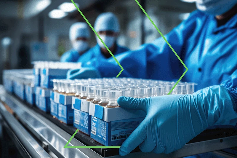 A person in lab gear picking up a box of pharmaceuticals with an outlined green right arrow intertwined, representing the supply chain and manufacturing.