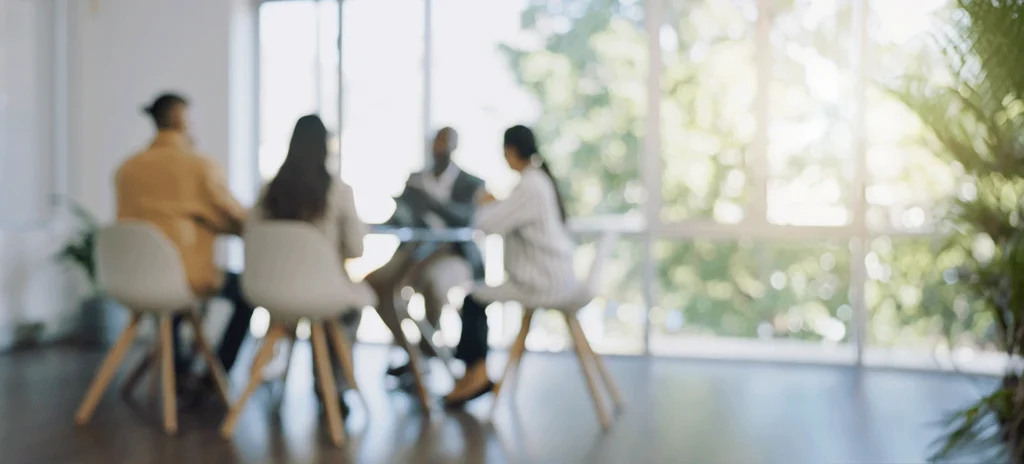Colleagues working together at a table, out of focus.